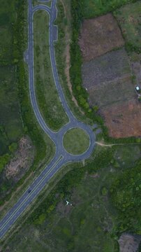 Roundabout Amid Trees. Aerial Perspective Of Lush Green Circular Junction. Elevated Perspective Highlighting Dense Forest Surrounding Circular Traffic Circle With Natural Buffer Zones