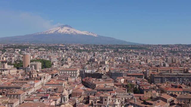 view of Mt. Etna descending behind Cathedral domes in Catania Sicily