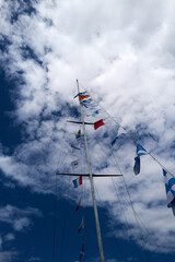 Obraz premium A tall pole with many maritime flags on it is in the sky