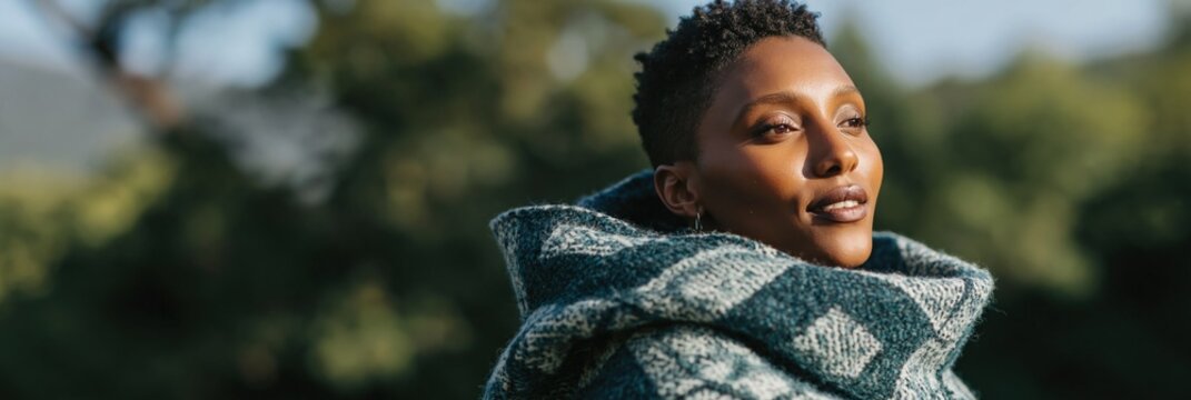 Young woman gazing into distance wrapped in patterned shawl outdoors