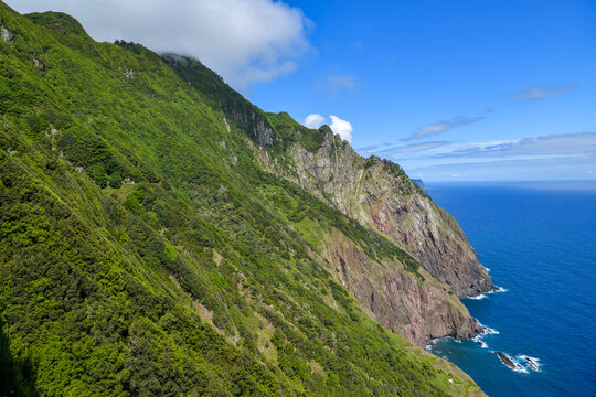 Steep lush green cliffs above blue Atlantic Ocean