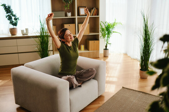 Woman feeling refreshed and waking up in her cozy living room at home