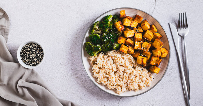 A plate of rice, fried tofu and broccoli on the table top view web banner