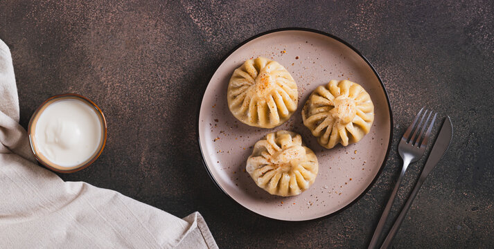 Traditional Georgian juicy khinkali dumplings on a plate top view web banner