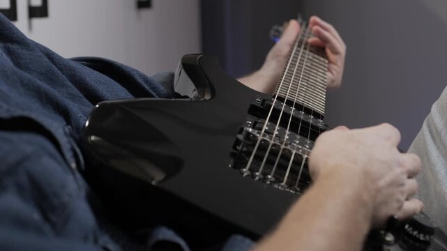 play electric guitar close up fingers slide over strings of electric guitar