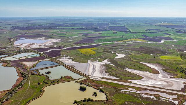 Aerial view of fish ponds and surrounding dry wetlands showing contrast of water and land
Aquaculture landscape meeting drying natural areas creating strong visual contrast