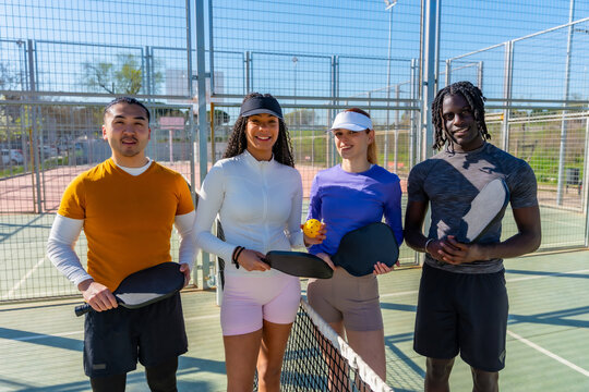 Diverse friends enjoying pickleball on outdoor court