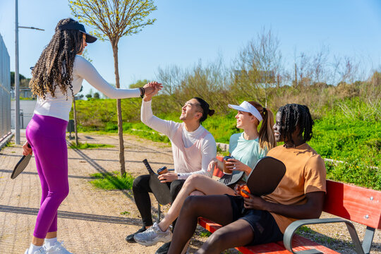Diverse friends giving high five after playing pickleball