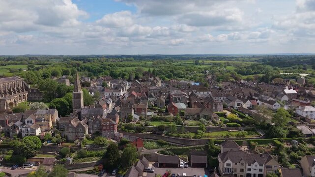 Aerial drone footage of Malmesbury, a historic market town in Wiltshire, England, nestled within the Cotswolds, Scenic view featuring traditional architecture, the River Avon