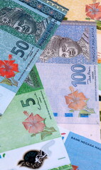 Malaysian ringgit money bills pile on table. Malaysia banknotes of MYR currency close up. © Larysa