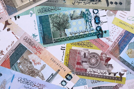 Sudanese pound money bills pile on table. Sudan banknotes of SDG currency close up.