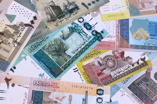 Sudanese pound money bills pile on table. Sudan banknotes of SDG currency close up.