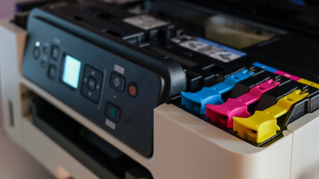Close-up view of a modern inkjet printer's ink cartridge system with colorful components