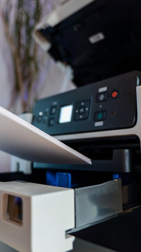 Close-up of a stack of paper being loaded into a modern office printer