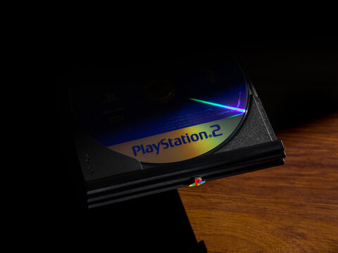 May 3, 2026, Odessa, Ukraine. Blue PlayStation 2 disc in an open console tray on a wooden surface.