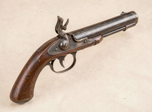A handgun placed on the grassy terrain, with an open trigger