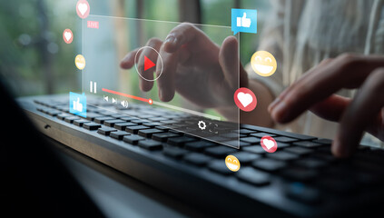 A person types on a keyboard with a holographic video player overlay showing social media reactions, representing modern digital content creation and online engagement. Ledger © InfiniteFlow