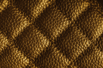 Fototapeta premium Close up, macro of yellow quilted leather texture with stitched diamond pattern, luxury material surface shining metal effect for fashion, upholstery or design wallpaper, rough, relief background