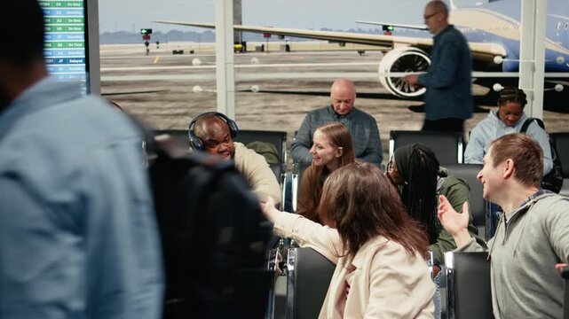Chatting, group and multiethnic friends in airport waiting for departure gate to open. Having fun, international flight and travel buddies in air transportation transit hub, camera A