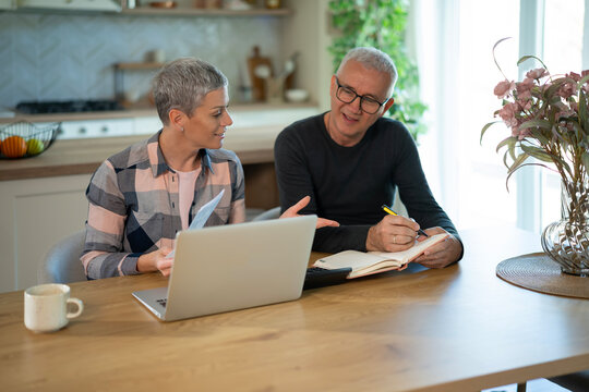 Mature couple managing finances together at home