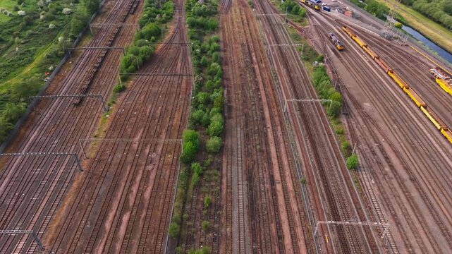 Aerial forward drone flight over multiple parallel railway tracks and rail network. Industrial transport, logistics and infrastructure concept.