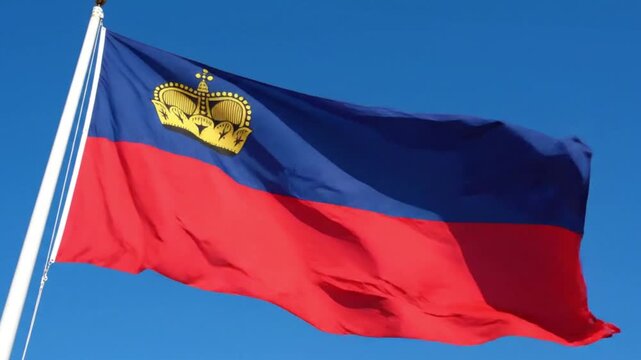 The national flag of liechtenstein waving against a clear blue sky