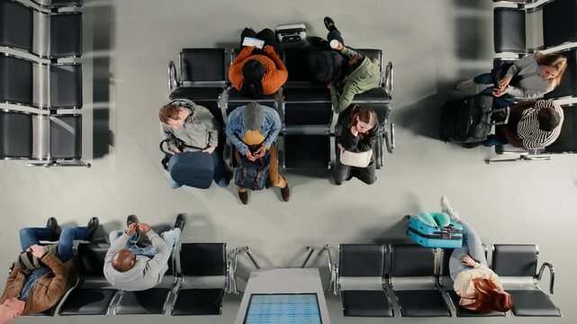 Waiting, vacation flight plane and top down view of diverse tourists in busy airport. Sitting on chairs, high angle shot and people in crowded departure terminal awaiting airplane boarding call
