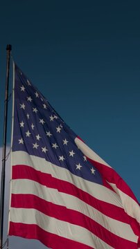 Vertical American Flag Waving In The Wind with Copy Space