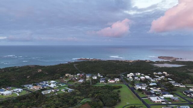 Sunrise over Beachport, South Australia: 4K aerial drone footage of coastal town, low density houses, estates, jetty, calm ocean, Southern Ocean Beach and golden morning light.