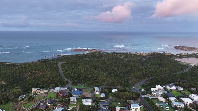 Sunrise over Beachport, South Australia: 4K aerial drone footage of coastal town, low density houses, estates, jetty, calm ocean, Southern Ocean Beach and golden morning light.