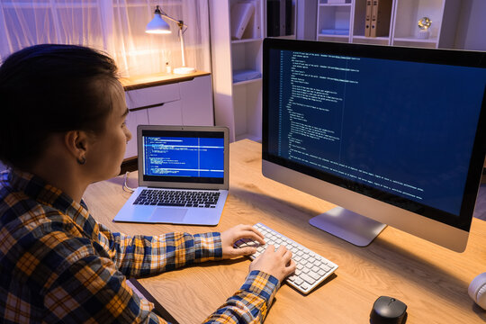 Female programmer working with computer in office at night