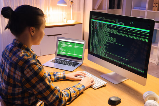 Female programmer working with computer in office at night