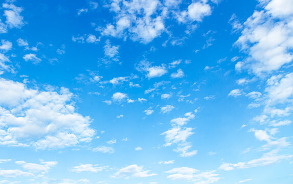 Panoramic vibrant blue sky background with white fluffy clouds and bright sunlight for natural backdrop and clean outdoor design