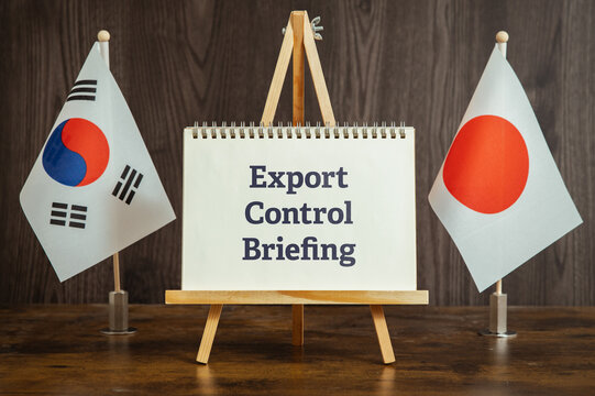 Conceptual image of Export Control Briefing shown on notebook with flags. Social awareness and corporate responsibility theme.