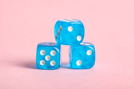 Blue game dices on pink background