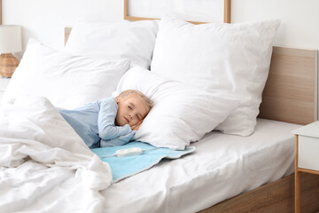 Cute little girl sleeping on electric heating pad in bedroom © Pixel-Shot