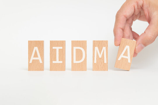 Eye-catching image of AIDMA text on wood blocks. The word stands for Attention, Interest, Desire, Memory, Action.
