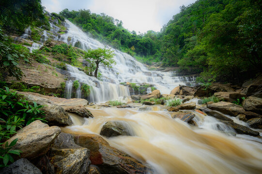 Majestic Mae Ya waterfall in Doi Inthanon National Park, Chiang Mai, Thailand, with silky water flowing over rocky tiers in a lush forest.