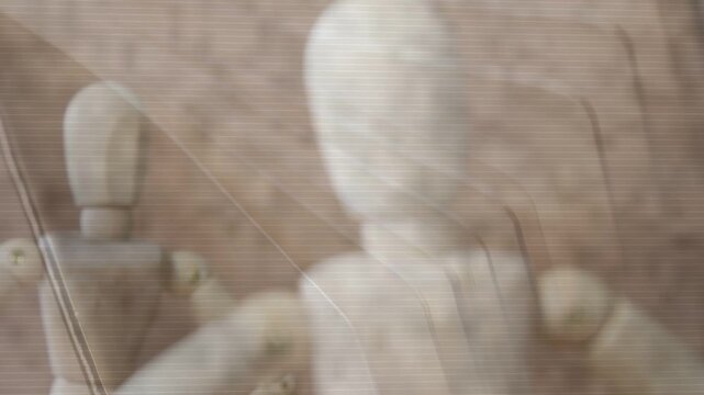 Focal pull moving front wooden mannequin toward center, bringing into focus to emphasize subject