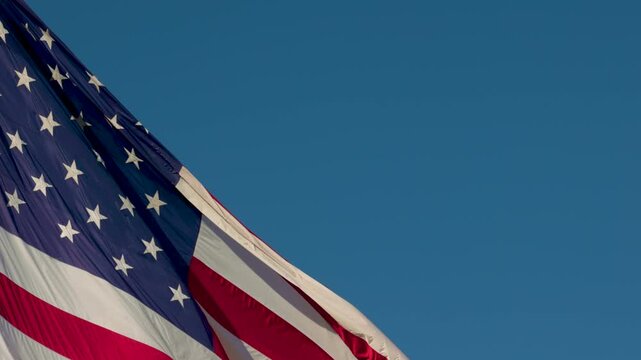 Slow Motion American Flag Waving with Copy Space Against Blue Sky