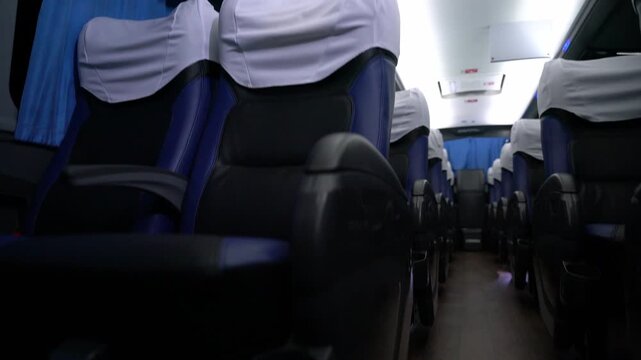 Empty interior of modern bus with passenger seats and blue lighting, public transportation, travel comfort and tourism service concept.