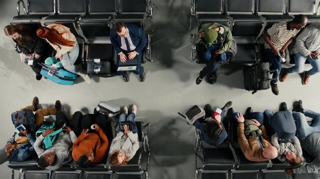 Boarding flight, departing airplane and tourists in airport lounge standing up from chairs, going to aircraft bridge. Going to boarding gate, trolleys and passengers leaving airport terminal