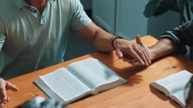 Top view of christian prayer holding each other support while reading bible books cross with faith, spirituality and religion. Close up of diverse people hands holding and praying to god. Symposium.