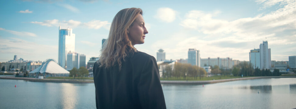 Successful professional woman overlooking city skyline dreaming of future with copy space