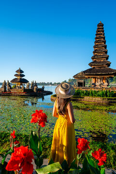 Young woman tourist relaxing and enjoying the beautiful view at Ulun Danu Beratan temple in Bali, Indonesia