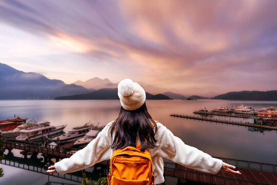 Solo female traveler enjoying a spectacular sunset over a scenic Sun Moon Lake in Taiwan