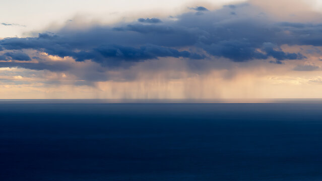 Dramatic Ocean Storm Clouds at Sunset with Rain Shaft.