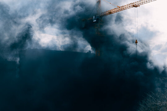Industrial building in clouds of toxic black smoke. Chemical hazard and environmental protection theme