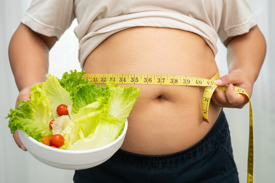 Asian woman with fat belly big size overweight and obesity with healthy food.