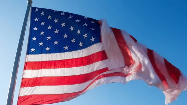 American flag waving against clear blue sky outdoor patriotic symbol